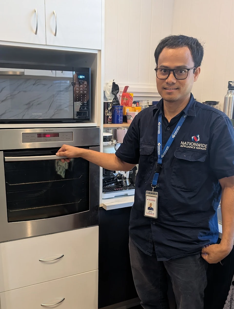 NAR technician holding the door handle of a Westinghouse electric oven.