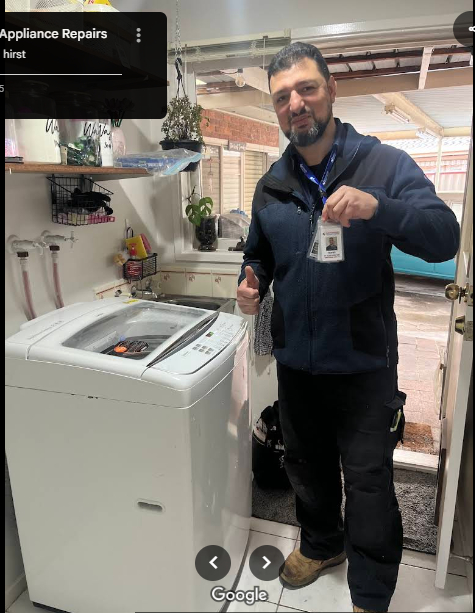 NAR technician standing in front of a repaired white washing machine, holding his ID badge.