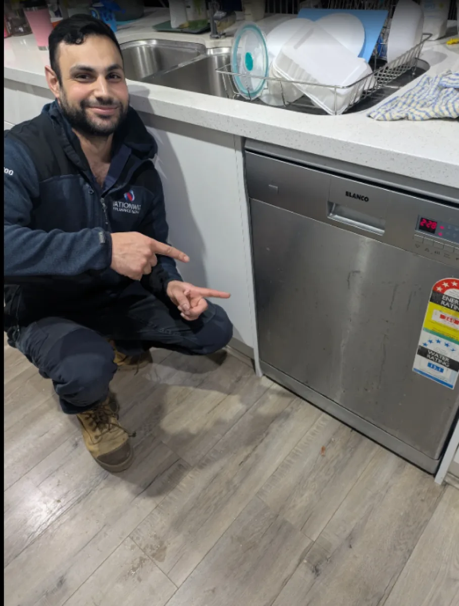NAR technician pointing with two hands at a Blanco dishwasher in a client’s home.