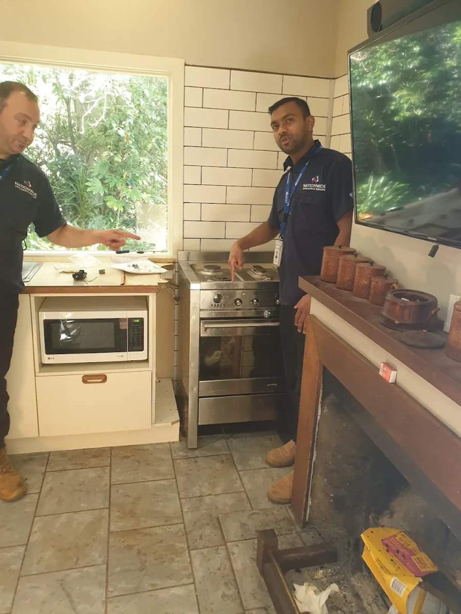 Two NAR technicians standing in front of a dual fuel oven in a client’s home.