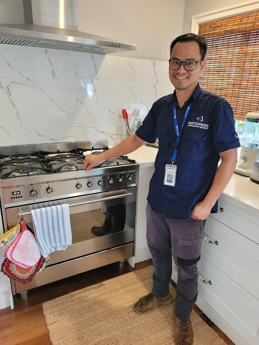 NAR technician posing in front of a dual fuel oven in a client’s home.