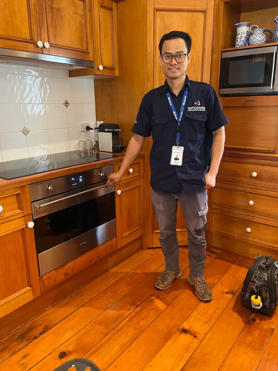 NAR technician standing in front of an electric cooktop.