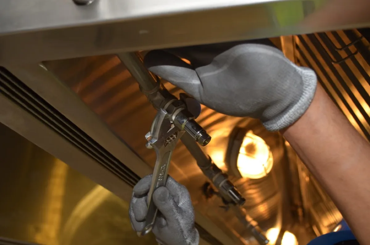 Man using a spanner fixing a line.
