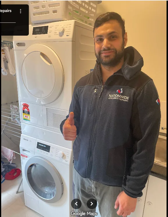 washing-machine-miele-with-technician NAR technician posing and giving thumb up in front of a repaired top-loading washing machine.