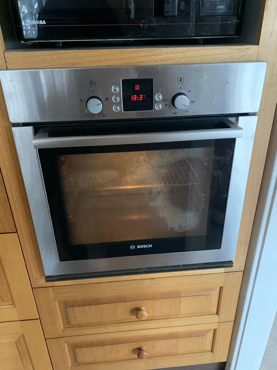 Bosch oven in a NAR’s client home, with the control panel lit up and displaying red numbers.