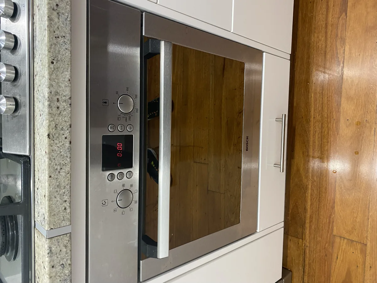 A Bosch oven in a client’s home, with the display lit up in red and showing zero numbers.