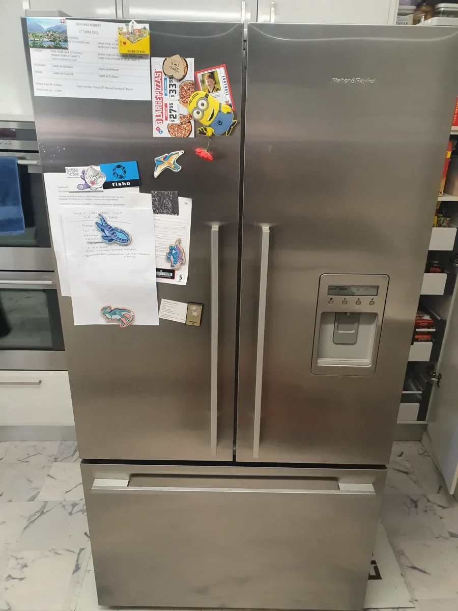 Fisher & Paykel refrigerator with a lot of notes and fridge magnets in a NAR’s client’s home.