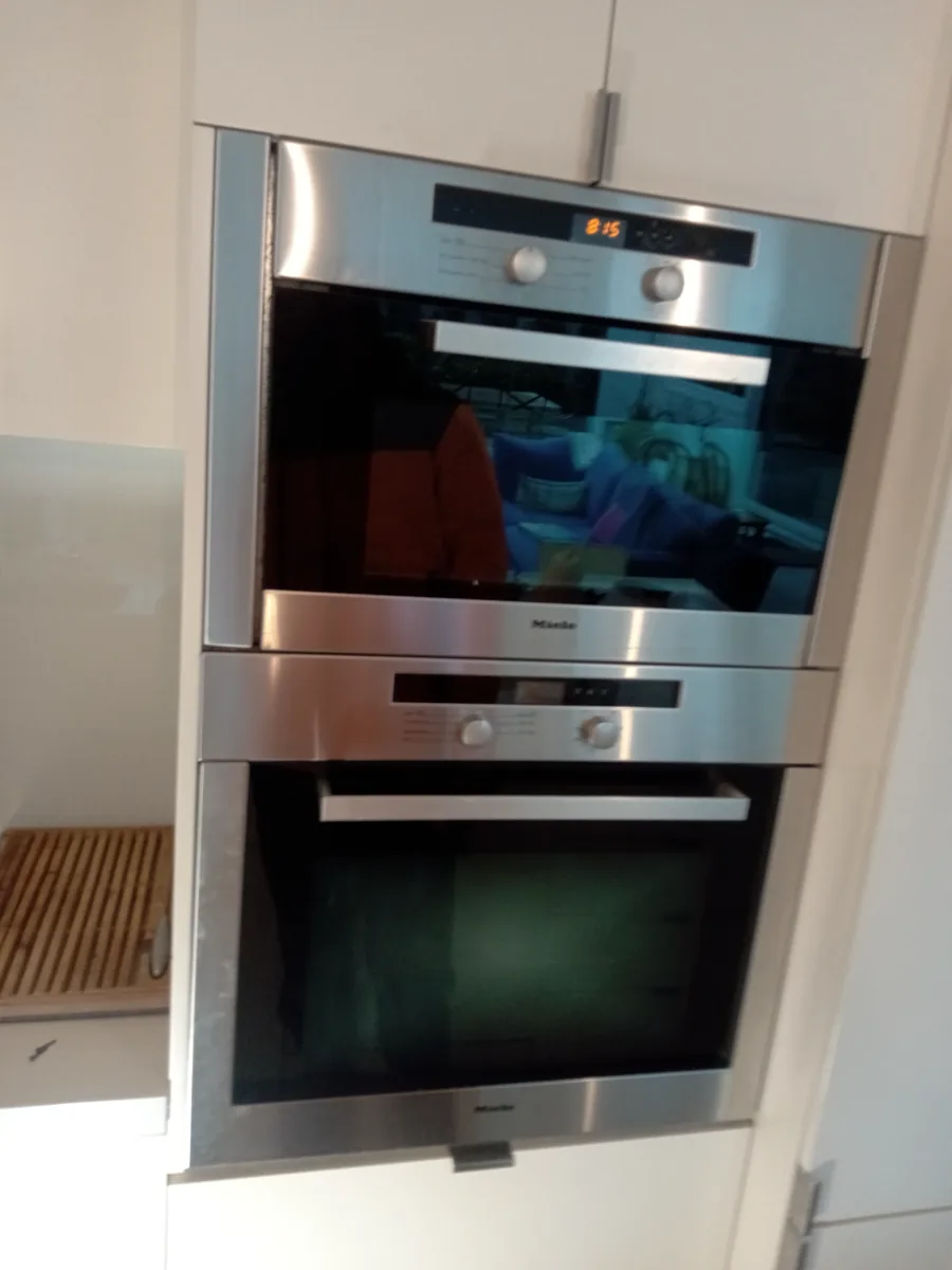 Miele oven in a client’s home with the display lit up and showing timing and numbers.