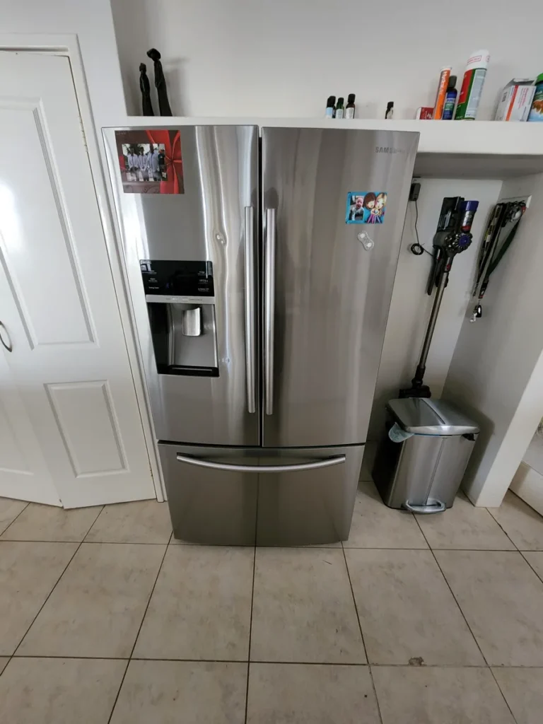 Samsung refrigerator with pinned photos on the door in a NAR’s client’s kitchen.