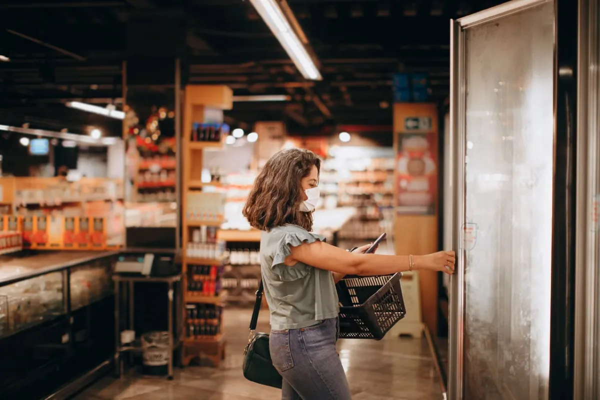 Person opening up a commercial-sized refrigerator’s door.